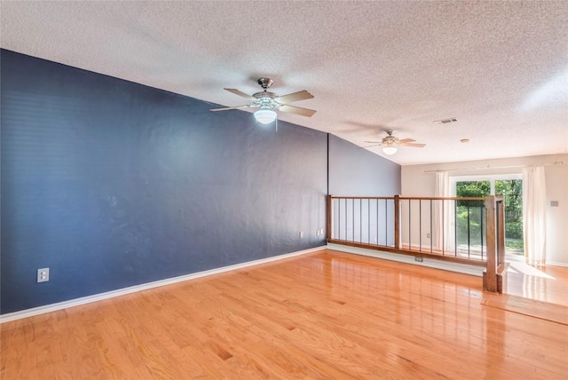 7507 Valburn Dr, Austin, TX 78731 - empty room with wood finished floors, a textured ceiling, a ceiling fan, and lofted ceiling