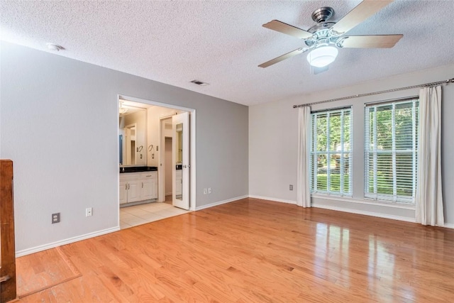7507 Valburn Dr, Austin, TX 78731 - empty room featuring a textured ceiling, light wood-type flooring, and ceiling fan