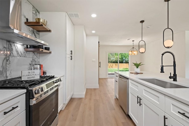 5603 Darlington Ln, Austin, TX 78723 - kitchen featuring open shelves, appliances with stainless steel finishes, wall chimney range hood, tasteful backsplash, and white cabinetry
