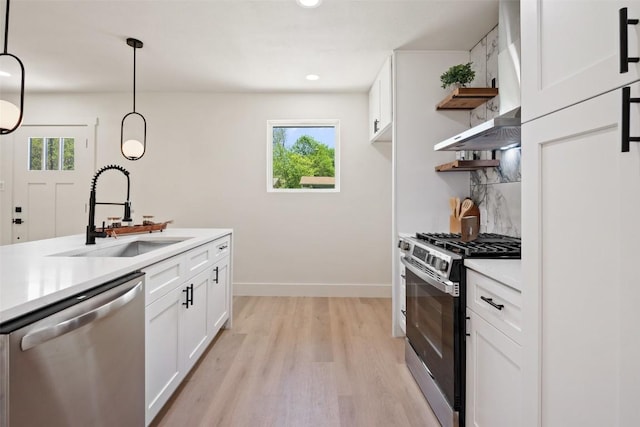 5603 Darlington Ln, Austin, TX 78723 - kitchen with stainless steel appliances, open shelves, light wood-style floors, light countertops, and white cabinets