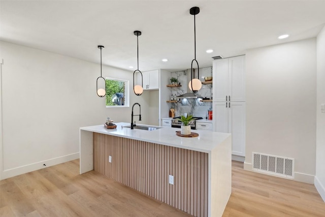 5603 Darlington Ln, Austin, TX 78723 - kitchen with light wood finished floors, white cabinets, decorative light fixtures, light countertops, and recessed lighting