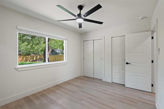 5603 Darlington Ln, Austin, TX 78723 - unfurnished bedroom with two closets, light wood-style floors, and a ceiling fan