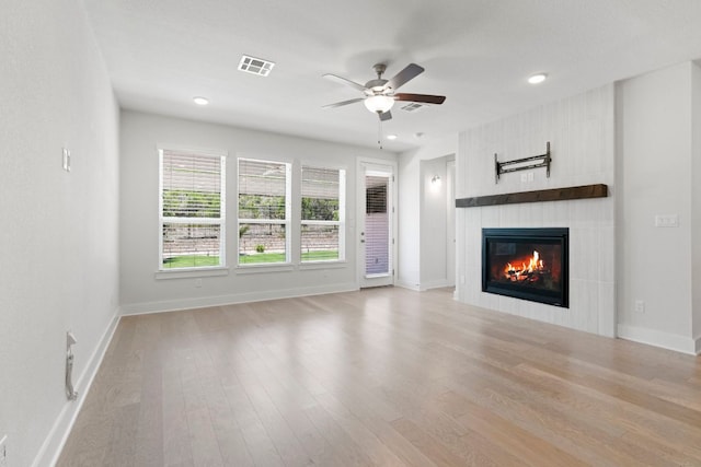 265 Tierra Trl, Dripping Springs, TX 78620 - unfurnished living room with a tiled fireplace, wood finished floors, a ceiling fan, and recessed lighting