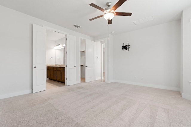 265 Tierra Trl, Dripping Springs, TX 78620 - unfurnished bedroom with light carpet, a walk in closet, ensuite bathroom, and ceiling fan