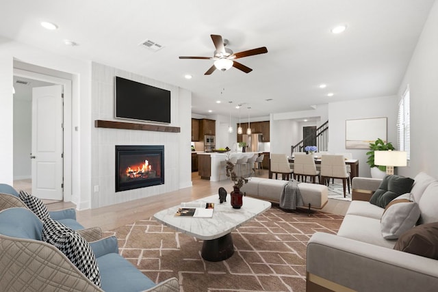 265 Tierra Trl, Dripping Springs, TX 78620 - living room with stairs, a ceiling fan, recessed lighting, a fireplace, and dark wood-style floors