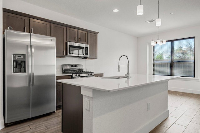 12315 Maypole Bnd Unit 1002, Austin, TX 78717 - kitchen with stainless steel appliances, dark brown cabinetry, light wood finished floors, hanging light fixtures, and recessed lighting