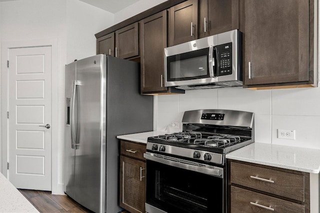 12315 Maypole Bnd Unit 1002, Austin, TX 78717 - kitchen with appliances with stainless steel finishes, dark brown cabinets, light stone counters, and dark wood-style floors