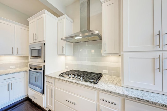 3105 Mccurdy St, Austin, TX 78723 - kitchen featuring stainless steel appliances, wall chimney range hood, decorative backsplash, white cabinetry, and light stone counters