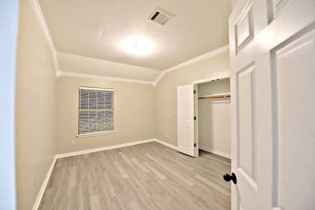 1933 Chasewood Dr, Austin, TX 78727 - unfurnished bedroom featuring ornamental molding, wood finished floors, vaulted ceiling, a textured ceiling, and a closet