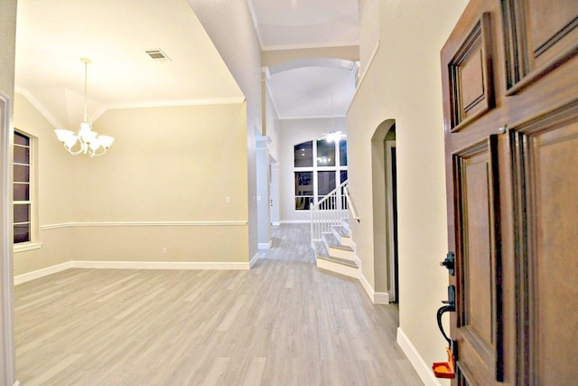 1933 Chasewood Dr, Austin, TX 78727 - entryway featuring arched walkways, a chandelier, light wood-style flooring, stairs, and crown molding