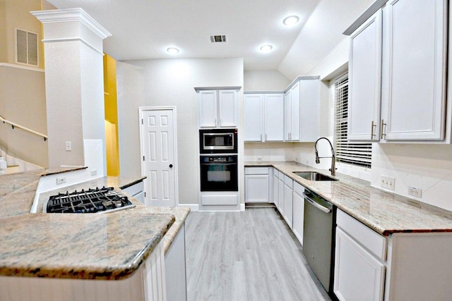 1933 Chasewood Dr, Austin, TX 78727 - kitchen featuring stainless steel appliances, light wood-type flooring, light stone counters, white cabinets, and lofted ceiling