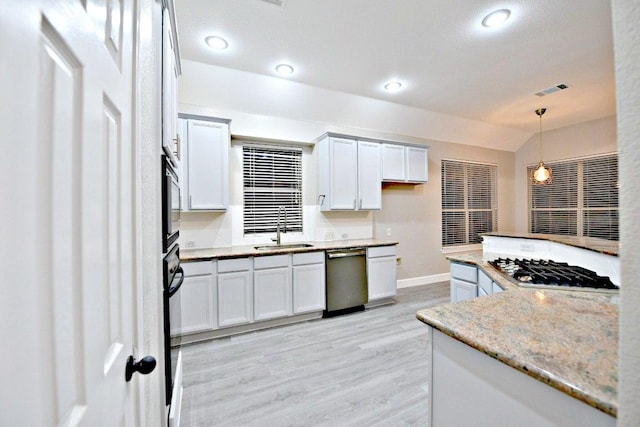 1933 Chasewood Dr, Austin, TX 78727 - kitchen with stainless steel appliances, decorative light fixtures, light wood-style floors, white cabinets, and recessed lighting