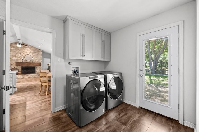 507 S Lake Creek Dr, Round Rock, TX 78681 - washroom featuring washer and dryer, cabinet space, dark wood finished floors, and a stone fireplace