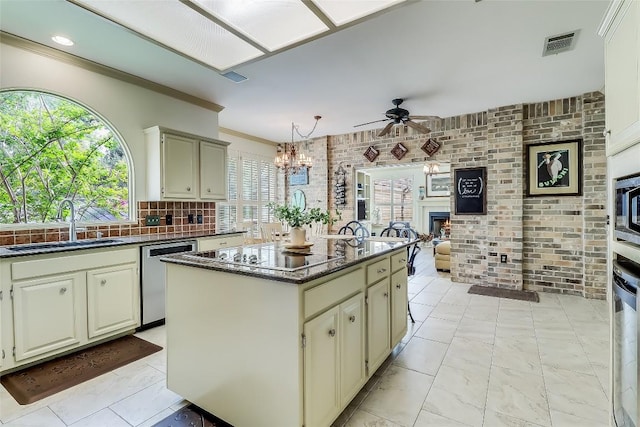 3110 Barton Point Dr, Austin, TX 78733 - kitchen featuring a ceiling fan, stainless steel appliances, cream cabinets, a chandelier, and a center island
