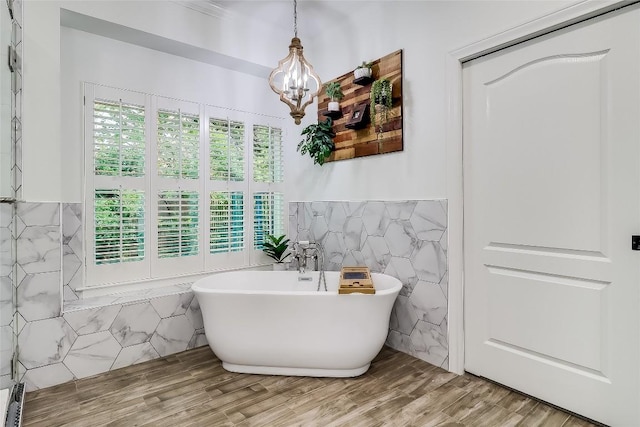3110 Barton Point Dr, Austin, TX 78733 - full bath with tile walls, a chandelier, a freestanding tub, wood finished floors, and wainscoting