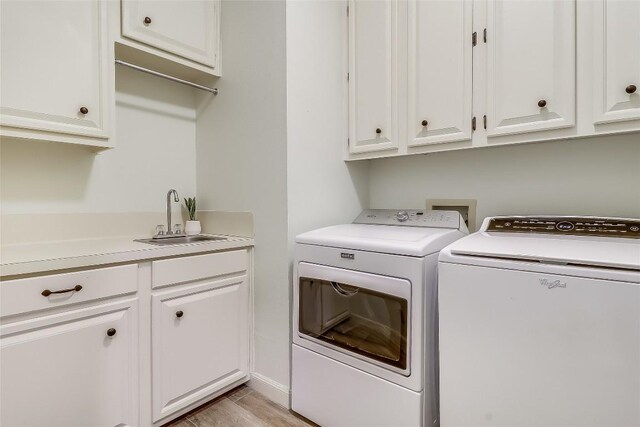 3110 Barton Point Dr, Austin, TX 78733 - laundry area featuring washing machine and clothes dryer, cabinet space, and light wood-style flooring