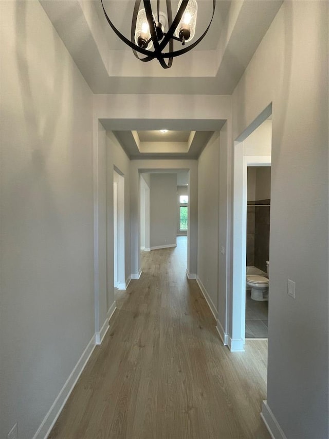 1824 Camay St, Leander, TX 78641 - corridor featuring a tray ceiling, a chandelier, and wood finished floors