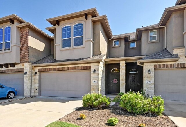 204 Parable Cv, Pflugerville, TX 78660 - townhome / multi-family property featuring a garage, stone siding, stucco siding, and concrete driveway
