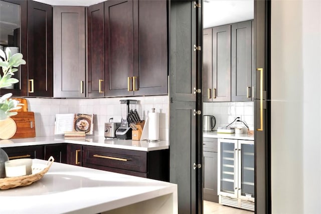 5806 Burnhill Dr, Austin, TX 78745 - kitchen featuring wine cooler, light countertops, tasteful backsplash, and dark brown cabinetry