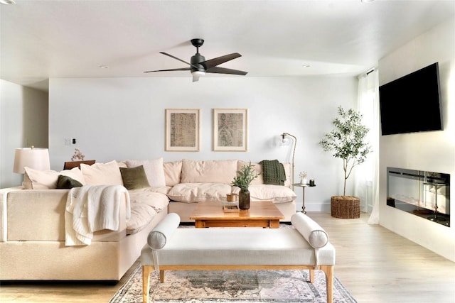 5806 Burnhill Dr, Austin, TX 78745 - living room featuring wood finished floors, a ceiling fan, and a glass covered fireplace