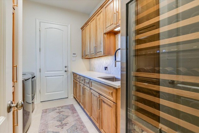 6717 Valburn Dr, Austin, TX 78731 - kitchen with wine cooler, washing machine and clothes dryer, light countertops, backsplash, and light tile patterned floors