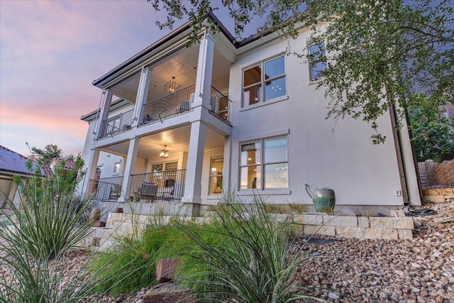 6717 Valburn Dr, Austin, TX 78731 - back of house at dusk with a balcony and stucco siding