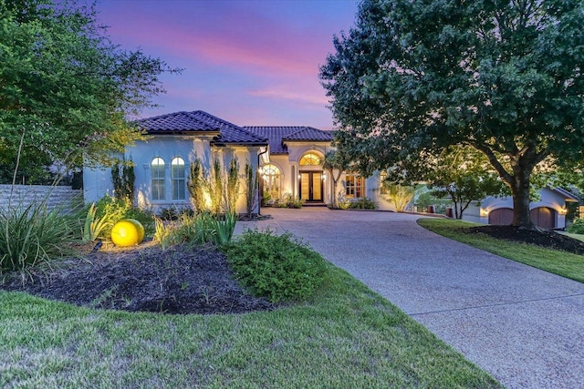 6717 Valburn Dr, Austin, TX 78731 - mediterranean / spanish house with a tiled roof, stucco siding, curved driveway, a lawn, and french doors