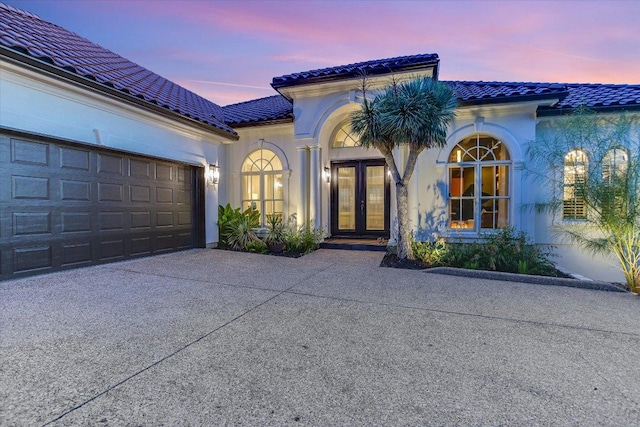 6717 Valburn Dr, Austin, TX 78731 - view of front of home featuring french doors, driveway, a tiled roof, and stucco siding