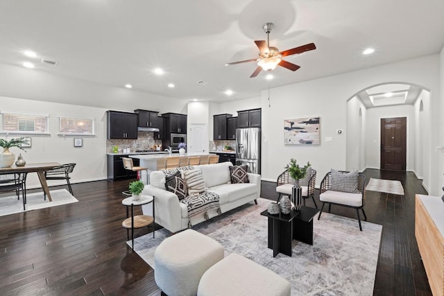 19825 Rhiannon Ln, Pflugerville, TX 78660 - living room featuring arched walkways, dark wood-type flooring, a ceiling fan, and recessed lighting