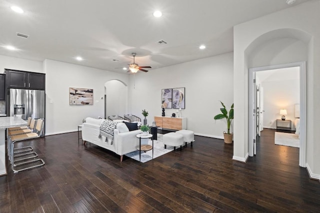 19825 Rhiannon Ln, Pflugerville, TX 78660 - bedroom with arched walkways, dark wood finished floors, stainless steel fridge with ice dispenser, and recessed lighting