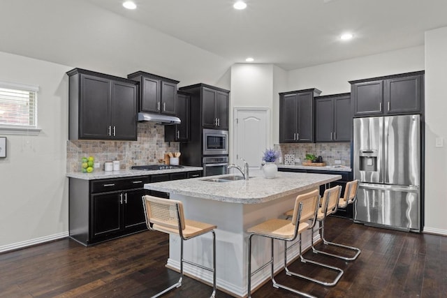 19825 Rhiannon Ln, Pflugerville, TX 78660 - kitchen featuring stainless steel appliances, decorative backsplash, dark wood-style flooring, a kitchen bar, and recessed lighting