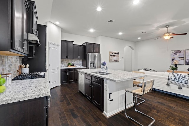 19825 Rhiannon Ln, Pflugerville, TX 78660 - kitchen with stainless steel appliances, arched walkways, a ceiling fan, open floor plan, and dark wood-style flooring