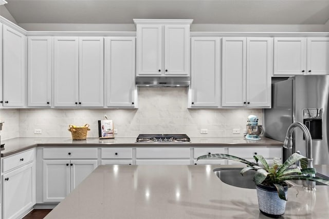 226 Brentwood Dr, Austin, TX 78737 - kitchen featuring appliances with stainless steel finishes, white cabinets, tasteful backsplash, and under cabinet range hood