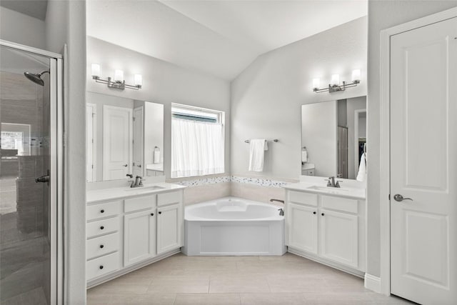 226 Brentwood Dr, Austin, TX 78737 - bathroom with a shower stall, two vanities, a bath, tile patterned floors, and vaulted ceiling