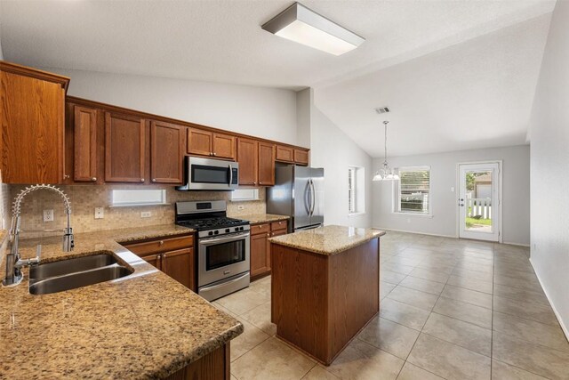 1704 Big Bend Dr, Cedar Park, TX 78613 - kitchen with appliances with stainless steel finishes, a center island, tasteful backsplash, brown cabinets, and high vaulted ceiling