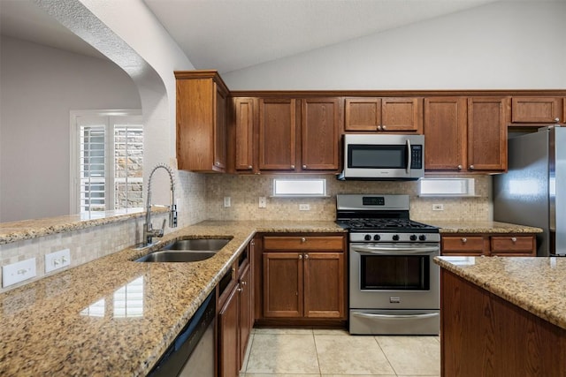 1704 Big Bend Dr, Cedar Park, TX 78613 - kitchen with appliances with stainless steel finishes, vaulted ceiling, light stone counters, and decorative backsplash