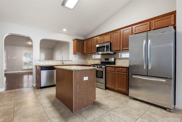1704 Big Bend Dr, Cedar Park, TX 78613 - kitchen with stainless steel appliances, a center island, arched walkways, vaulted ceiling, and decorative backsplash