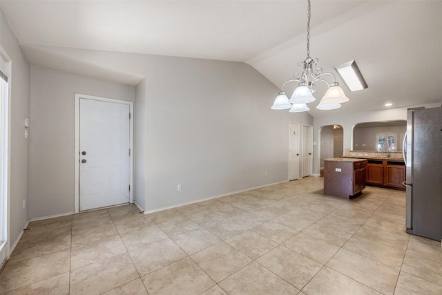 1704 Big Bend Dr, Cedar Park, TX 78613 - kitchen with freestanding refrigerator, arched walkways, lofted ceiling, light tile patterned flooring, and backsplash