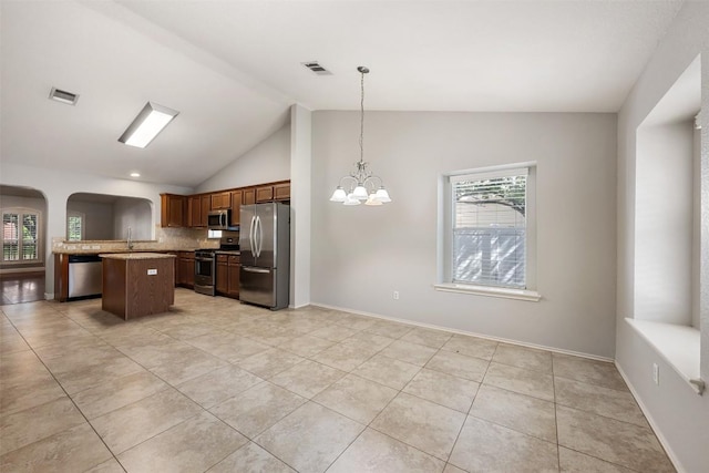 1704 Big Bend Dr, Cedar Park, TX 78613 - kitchen featuring appliances with stainless steel finishes, lofted ceiling, light tile patterned flooring, backsplash, and a chandelier