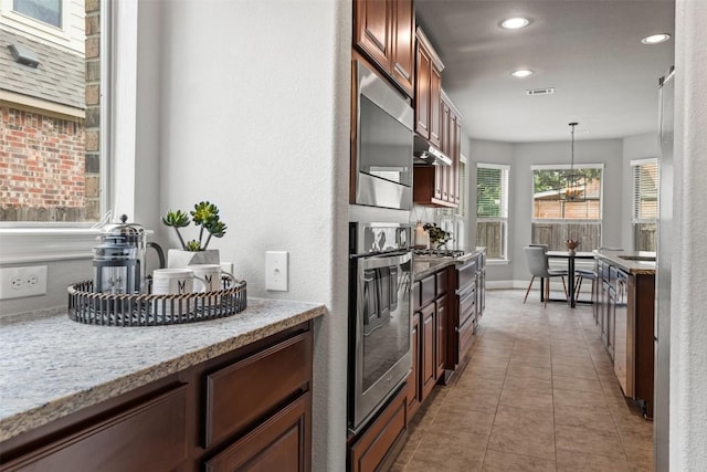 3041 Agave Loop, Round Rock, TX 78681 - kitchen featuring oven, recessed lighting, decorative light fixtures, light stone countertops, and light tile patterned floors