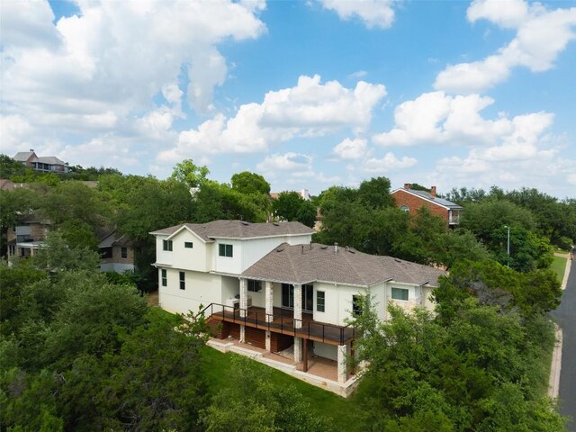 4001 Firstview Dr, Austin, TX 78731 - back of property with a wooden deck, stucco siding, roof with shingles, and view of wooded area