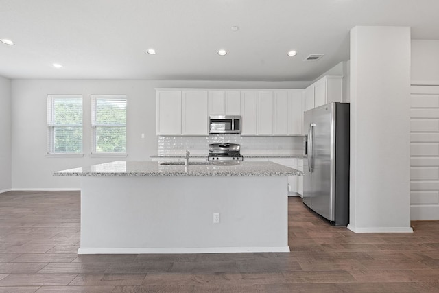 2800 Joe Dimaggio Blvd Unit 84, Round Rock, TX 78665 - kitchen featuring appliances with stainless steel finishes, backsplash, recessed lighting, a kitchen island with sink, and light stone countertops