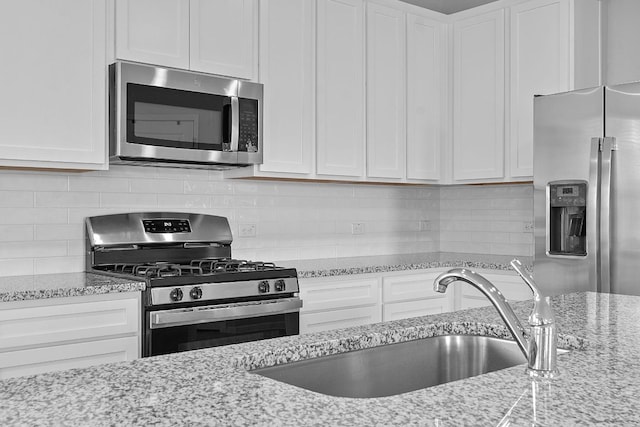 2800 Joe Dimaggio Blvd Unit 84, Round Rock, TX 78665 - kitchen featuring stainless steel appliances, white cabinets, tasteful backsplash, and light stone counters