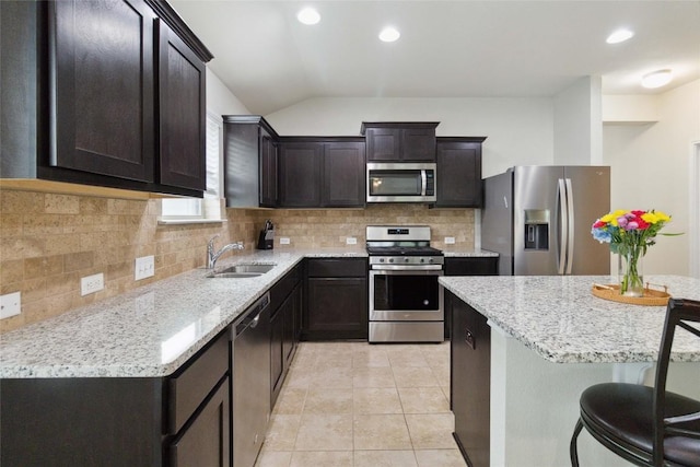 132 Sage Meadows Dr, San Marcos, TX 78666 - kitchen with stainless steel appliances, decorative backsplash, lofted ceiling, light tile patterned floors, and light stone counters