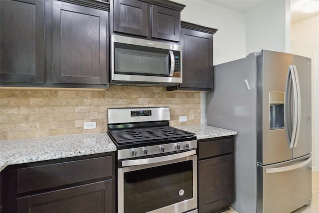 132 Sage Meadows Dr, San Marcos, TX 78666 - kitchen featuring stainless steel appliances, dark brown cabinetry, tasteful backsplash, and light stone counters