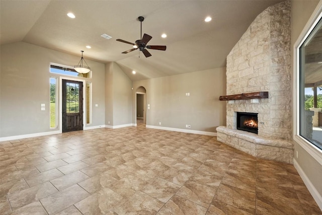 306 Anns Way, Blanco, TX 78606 - unfurnished living room featuring vaulted ceiling, plenty of natural light, a fireplace, arched walkways, and a ceiling fan