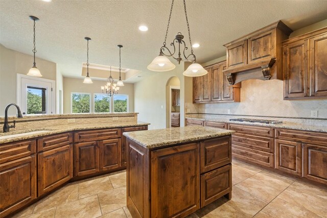 306 Anns Way, Blanco, TX 78606 - kitchen with stainless steel gas stovetop, arched walkways, backsplash, a textured ceiling, and custom range hood
