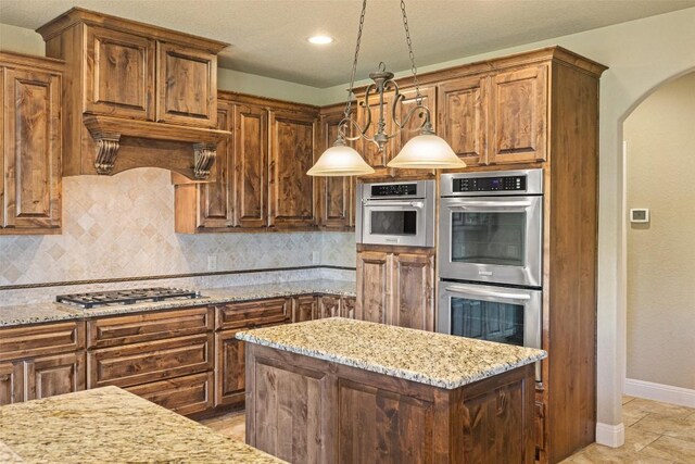 306 Anns Way, Blanco, TX 78606 - kitchen featuring appliances with stainless steel finishes, arched walkways, decorative backsplash, light stone countertops, and recessed lighting