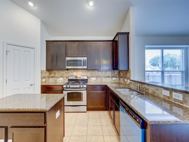 11600 Yeadon Way, Austin, TX 78717 - kitchen featuring stainless steel appliances, light stone counters, backsplash, and light tile patterned flooring