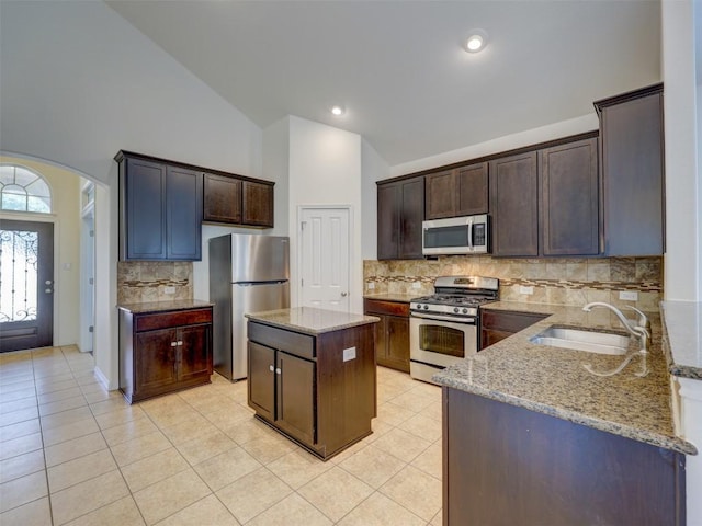 11600 Yeadon Way, Austin, TX 78717 - kitchen with stainless steel appliances, light stone countertops, light tile patterned floors, dark brown cabinets, and high vaulted ceiling